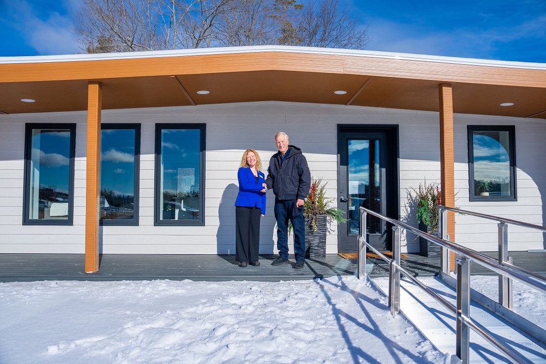 Kara Hay, CEO and President of Penquis, with U.S. Senator Angus King outside the printed home